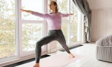 woman doing Yoga pose in front of window