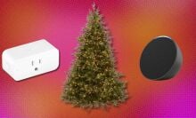 a pre-lit holiday tree sits between an amazon echo pop smart speaker and a smart plug