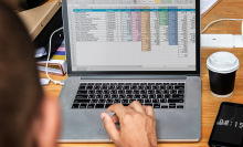 Someone typing on a computer with an open spreadsheet file