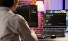 man coding on monitors