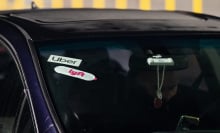 Lyft and Uber signage on a car at San Francisco International Airport (SFO) in San Francisco, California, US, on Thursday, Feb. 8, 2024. Lyft Inc. is scheduled to release earnings figures on February 13.