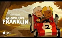 Charlie Brown and Franklin Armstrong ride in a soapbox car through the woods.