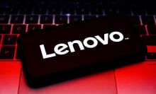 Lenovo logo displayed on a smart phone on top of a laptop keyboard.