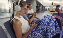 girl on phone in airport terminal wearing sony wh-1000xm5 headphones