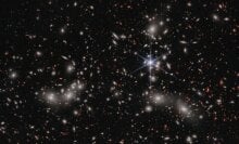 The galaxy group Pandora’s Cluster sits in front of a cosmic background brimming with deep space galaxies.