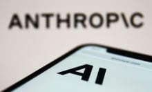 Anthropic website displayed on a phone screen and Anthropic logo displayed on a screen in the background are seen in this illustration photo taken in Krakow, Poland on September 26, 2023.