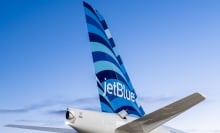 The tail of a JetBlue plane as it flies through the air