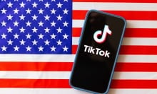 TIkTok logo on mobile phone with the American flag in the background.