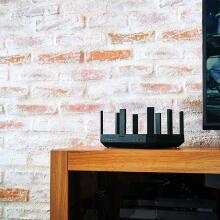 router on wooden stand against brick wall