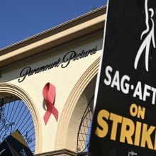 A black poster reading "SAG-AFTRA on strike!" outside the Paramount Pictures gate in Hollywood.