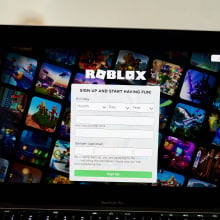 A laptop screen displaying the Roblox home page.
