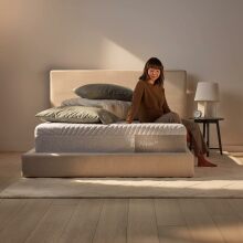 Woman sits on a Casper Sleep Wave Memory Foam mattress.