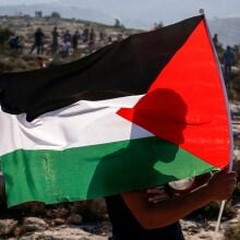 A Palestinian protester waves a Palestinian flag during a demonstration in the village of Ras Karkar west of Ramallah.