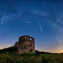 Meteors in the sky above some ancient ruins