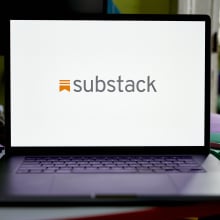 An open laptop displaying the Substack logo.