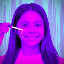 A girls applying serum in spooky purple and pink lighting. 