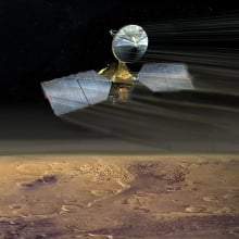 An artist's conception of the Mars Reconnaissance Orbiter swooping over the Martian desert.