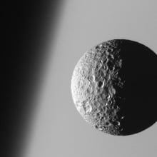 Mimas moon orbiting Saturn