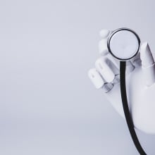 A robot hand holds a magnifying glass.