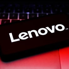 Lenovo logo displayed on a smart phone on top of a laptop keyboard.