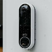 an arlo video doorbell is mounted to the side of a home and it's wet with raindrops