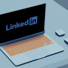 A mockup of the LinkedIn logo on a laptop sitting on a white desk.