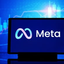 A computer displaying the Meta logo.