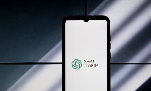 A phone displaying the ChatGPT logo against a shadowed backdrop.