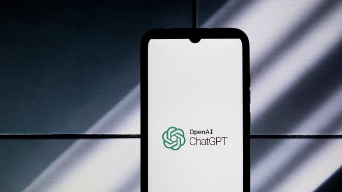 A phone displaying the ChatGPT logo against a shadowed backdrop.