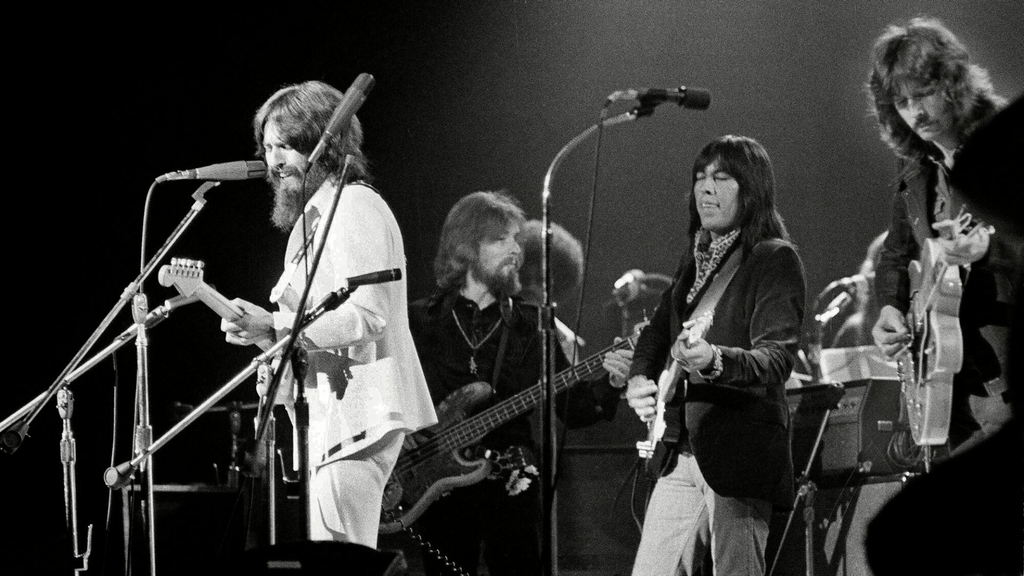 A live concert still from "Rumble: The Indians Who Rocked the World" featuring George Harrison, Klaus Voorman, Jesse Ed Davis, and Eric Clapton.