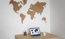 Laptop on table with map on wall