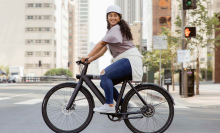 woman on bird e-bike riding down street