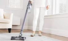 woman vacuuming carpet with Shark Pet cordless vacuum