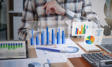 man sitting at desk with graphics floating around him