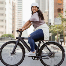 woman on bird e-bike riding down street