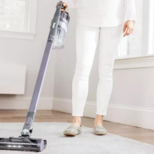 woman vacuuming carpet with Shark Pet cordless vacuum