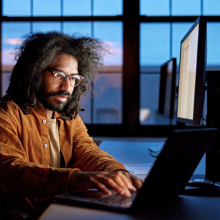 man with glasses and beard working on windows desktop computer