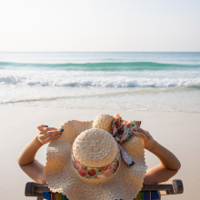 woman laying on beach in sun hat