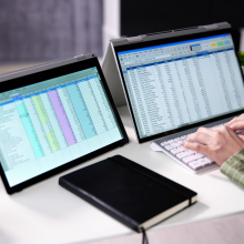 person using microsoft excel on two screens