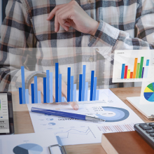 man sitting at desk with graphics floating around him