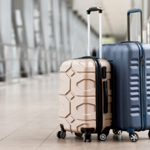 Travel Fashion. Closeup Shot Of Two Plastic Suitcases Standing At Empty Airport Corridor, Stylish Luggage Bags Waiting At Terminal Hall, Banner For Air Travelling And Vacation Booking Concept