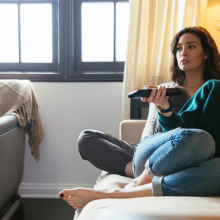 two women sitting on couch watching TV