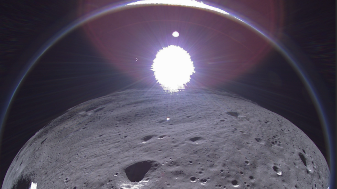 A transmission from Intuitive Machines' Odysseus moon lander showing the crescent Earth near the top of the image, to the left of center.