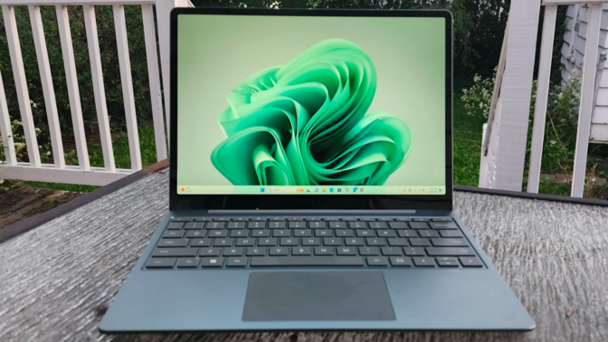 the microsoft surface laptop go 3 sitting on a patio table outside at dusk
